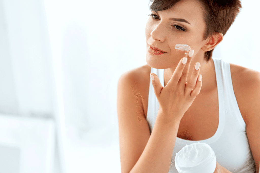 Woman moisturizing her face