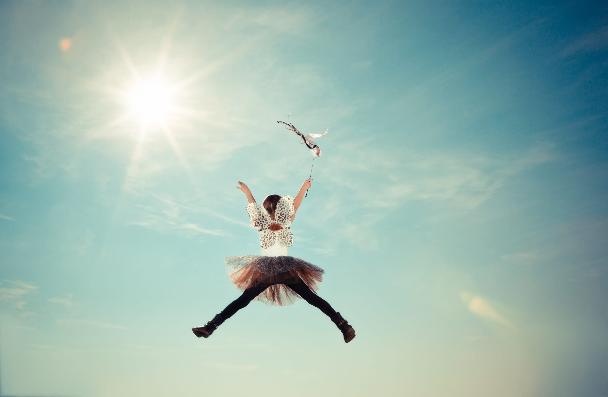 child dressed as a fairy jumping