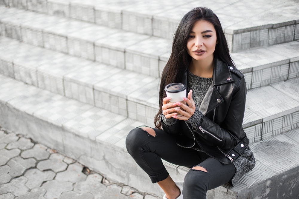 girl sitting on steps holding a coffee