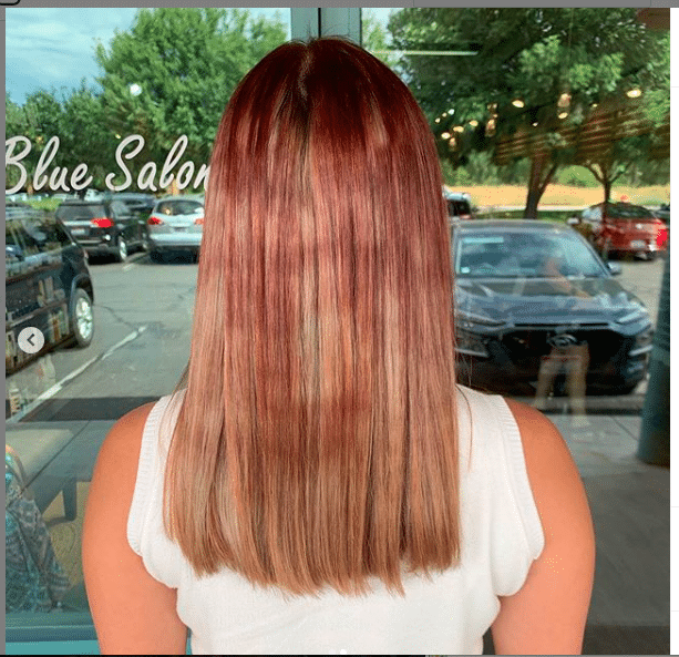 Before photo of a mid-length hair in need of a color correction (bad blend of blonde and red)