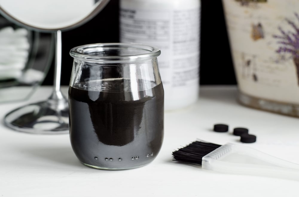 charcoal mask in clear jar on vanity table