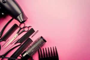 hairstylist's products laying out on a pink background