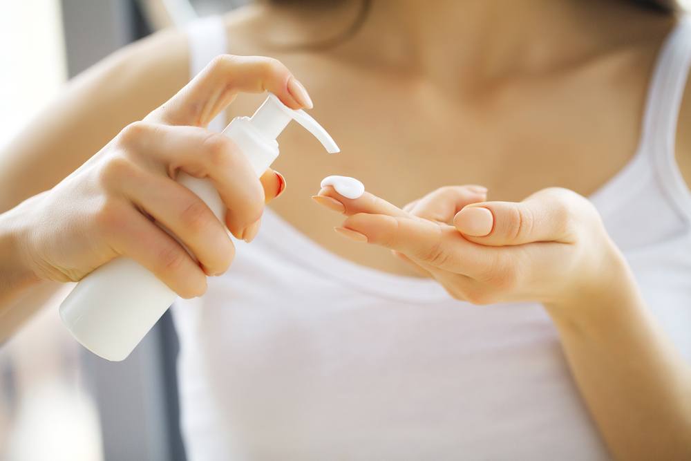 woman applying moisturizer