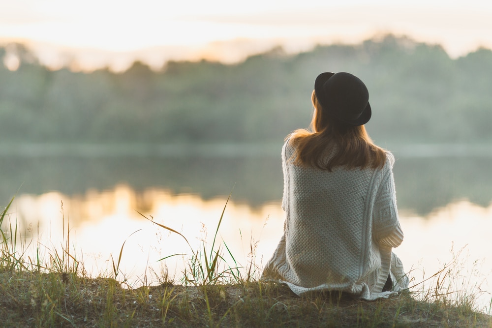woman looking at lake and thinking back