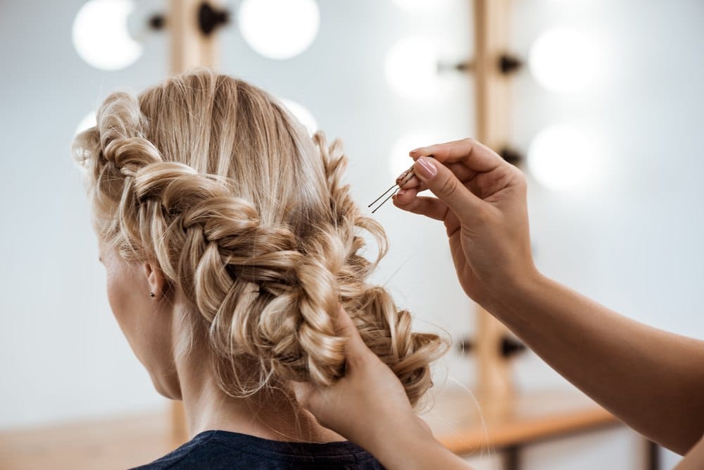 cosmetologist pinning woman's hair up