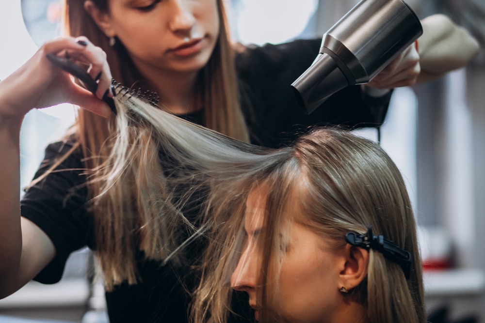 cosmetologist helping client with hair
